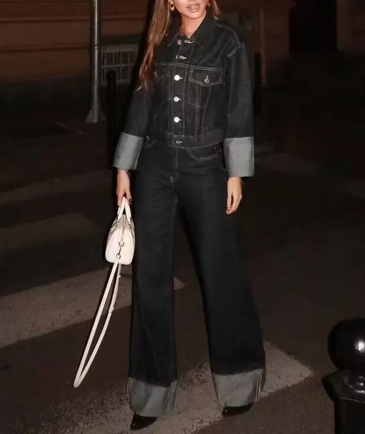 Person wearing a denim outfit with a handbag, standing on a staircase with 'Trafz' branding.