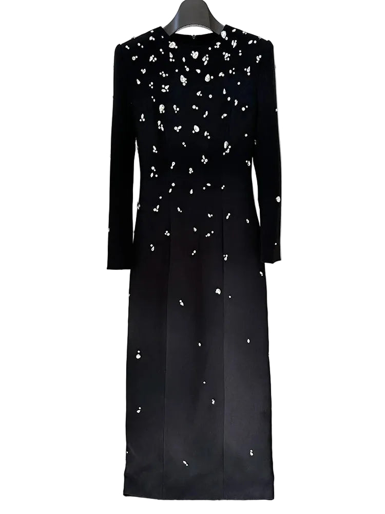 Black dress with white floral embellishments on a hanger against a white background