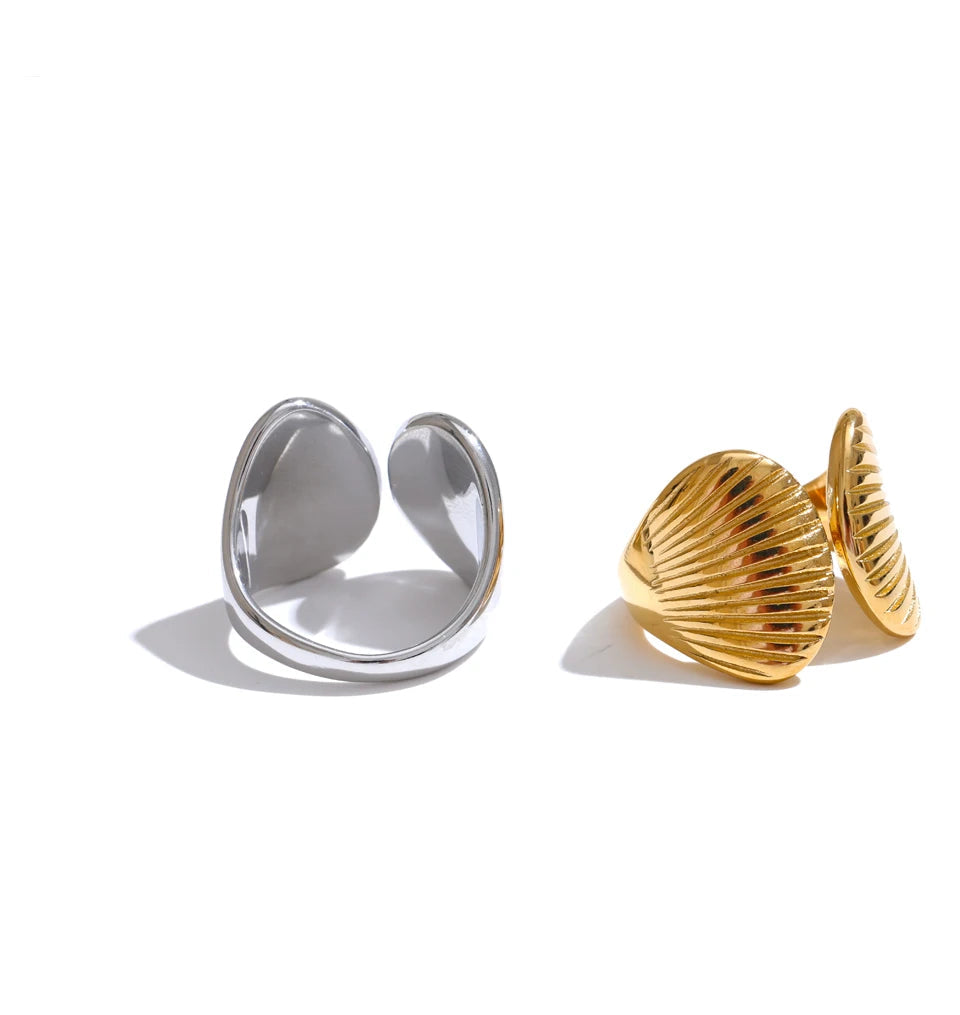 Gold and silver shell-shaped earrings on a white background