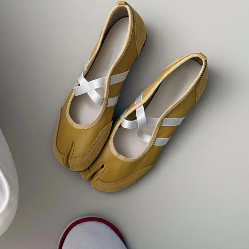 Pair of mustard yellow shoes with white ribbons on a light gray background