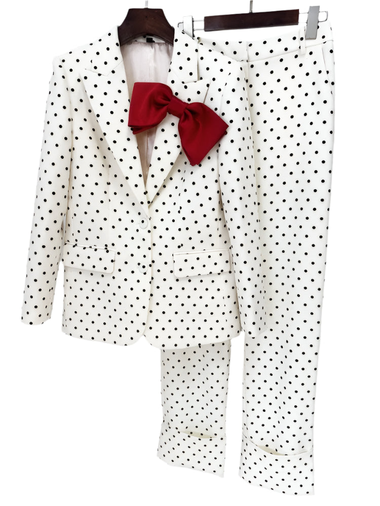 White polka dot suit with a red bow tie on a hanger against a white background