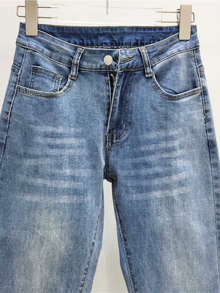 Blue jeans with glittery cuffs on a white background