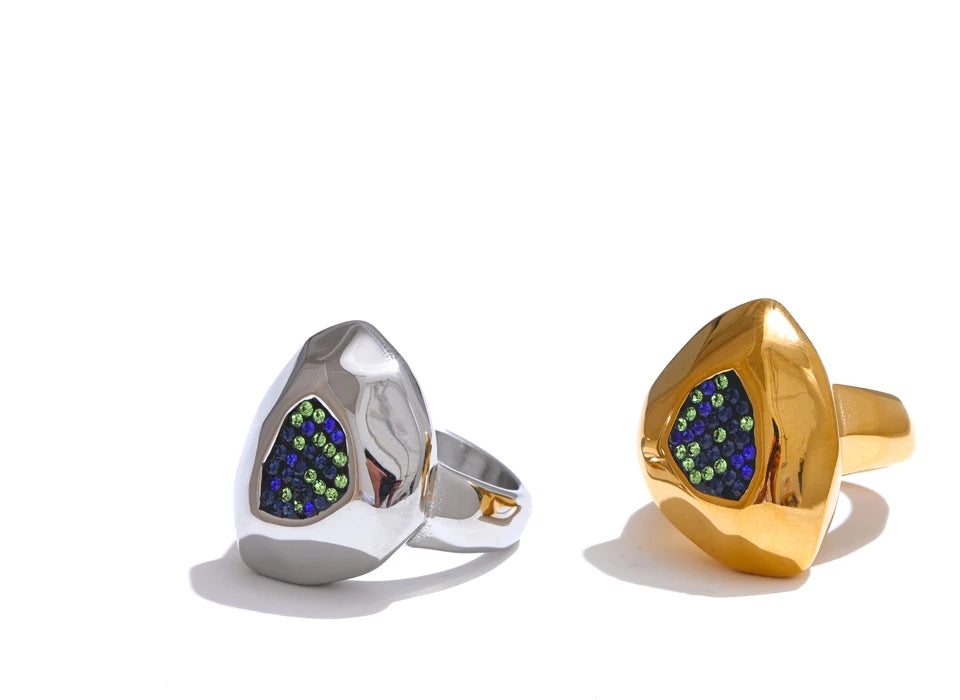 Two rings, one silver and one gold, with gemstones on a white background