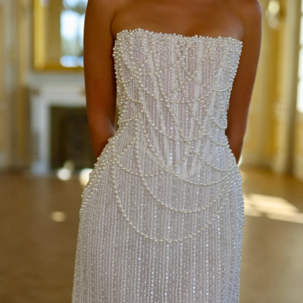 Beaded strapless gown with a blurred indoor background
