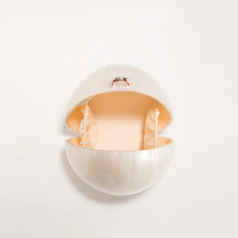 Round white container with gold interior on a light gray background