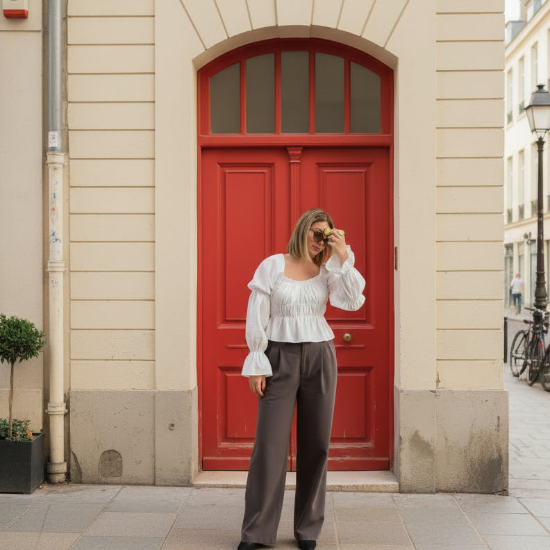 Woman holding a handbag in front of a red door.