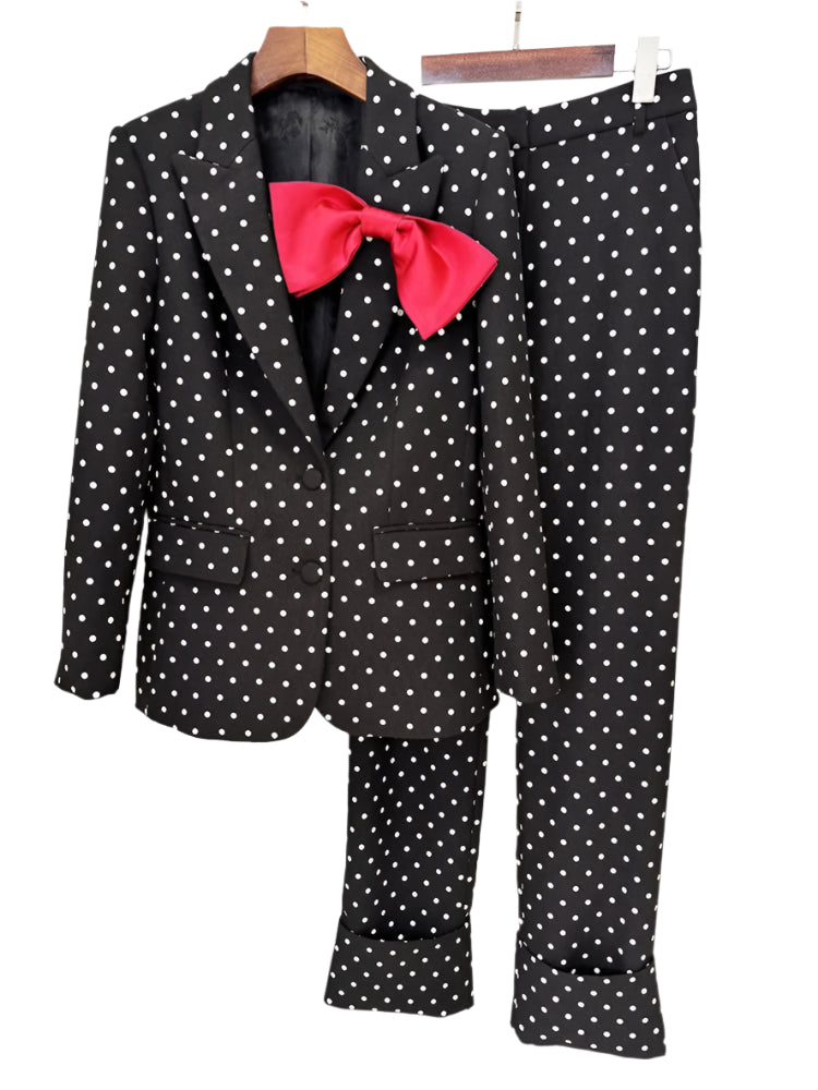 Black polka dot suit with a pink bow tie on a white background