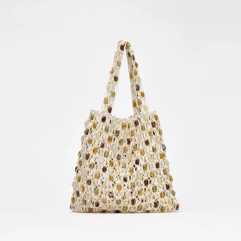 Woven beaded handbag with a neutral color palette on a light gray background