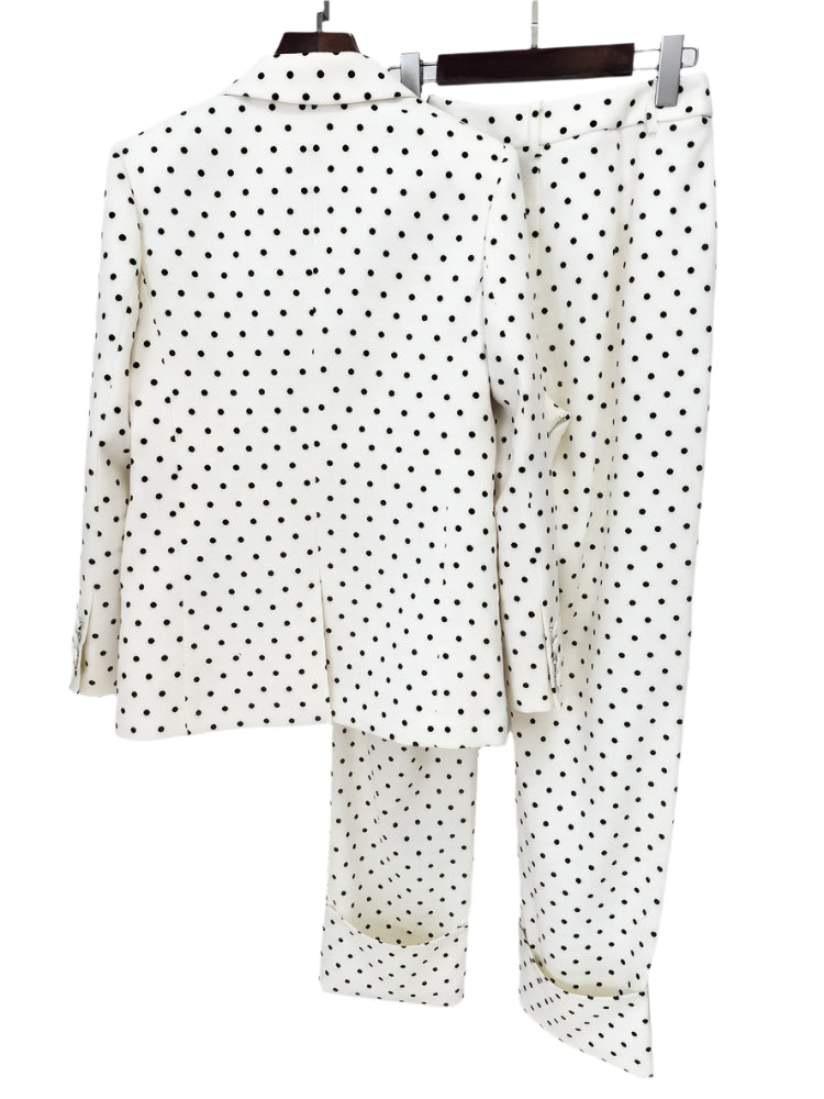 Polka dot shirt and pants set on a hanger against a white background