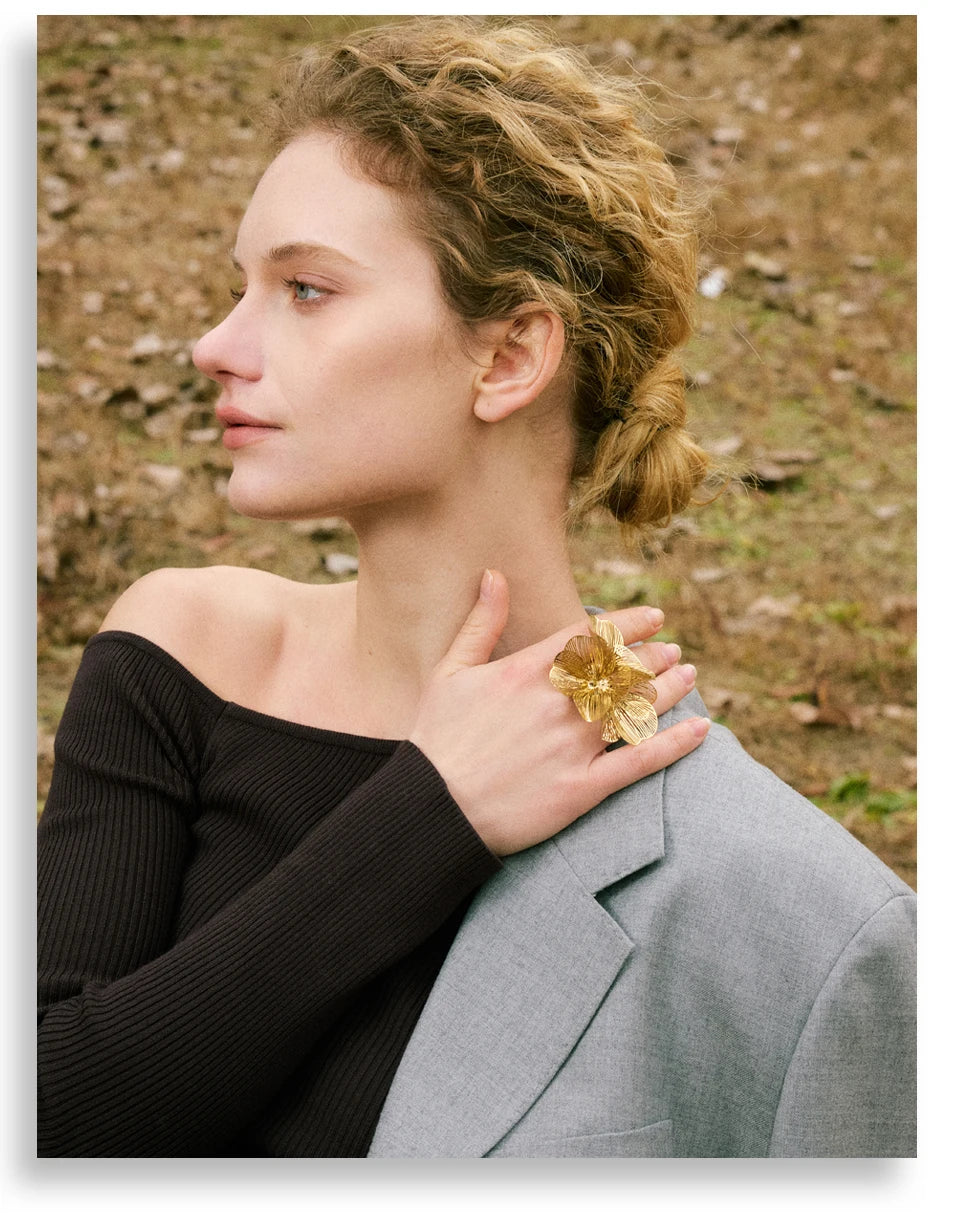 Woman holding a gold ring with a field in the background
