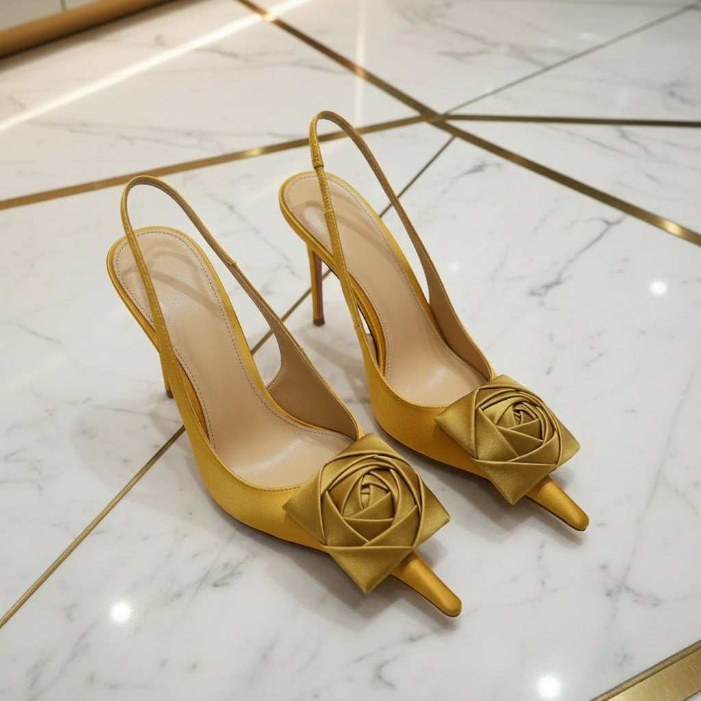 Yellow high-heeled shoes with floral designs on a gray floor.