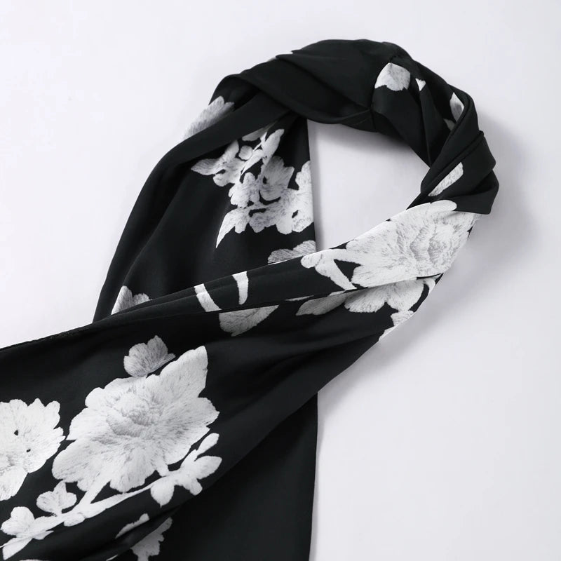 Black scarf with white floral patterns on a white background