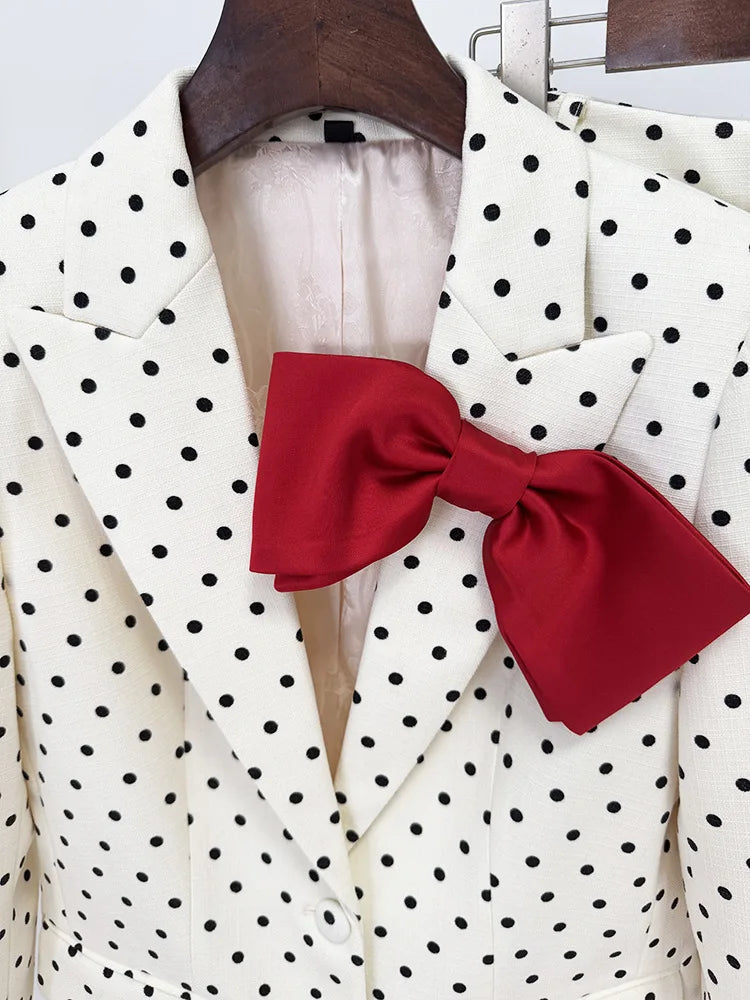 White polka dot blazer with a red bow tie on a hanger