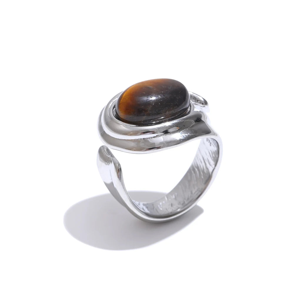 Silver ring with a brown stone on a white background